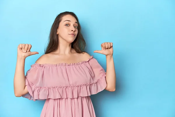 Jonge Vrouw Draagt Een Roze Jurk Een Blauwe Studio Achtergrond — Stockfoto