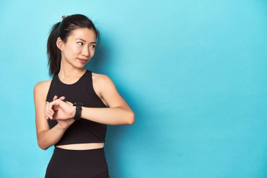 Asyalı sporcu kadın, etkinlikten önce akıllı hareket ayarlıyor.