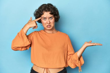 Kısa saçlı, elinde ürünü olan beyaz bir kadın..