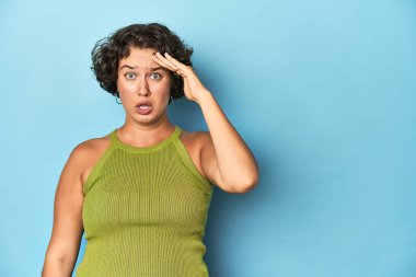 Kısa saçlı genç beyaz kadın yüksek sesle bağırıyor, gözlerini açık ve ellerini gergin tutuyor..