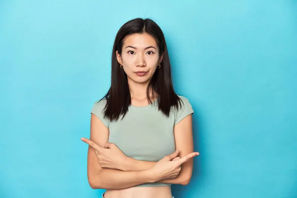 Asian Woman Summer Green Top Studio Backdrop Points Sideways Trying — Stock Photo, Image