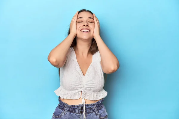 Κομψή Νεαρή Γυναίκα Λευκή Μπλούζα Μπλε Φόντο Στούντιο Γελάει Χαρούμενα — Φωτογραφία Αρχείου