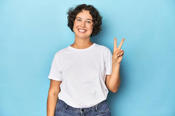 短い髪の喜びと指の平和のシンボルを示すケアフリーの若い白人女性 — ストック写真