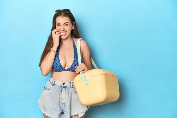 Portatif Plaj Soğutuculu Bikinili Bir Kadın Mavi Stüdyo Tırnaklarını Yiyor — Stok fotoğraf