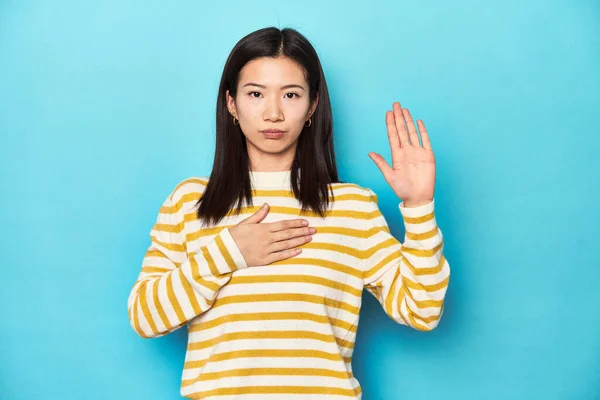 Asian Woman Striped Yellow Sweater Taking Oath Putting Hand Chest — Stock Photo, Image