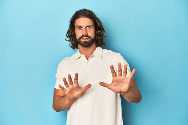 Long Haired Man White Polo Blue Studio Rejecting Someone Showing — Stock Photo, Image