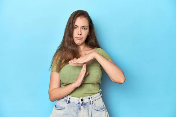 Jonge Blanke Vrouw Een Groene Top Een Blauwe Achtergrond Met — Stockfoto