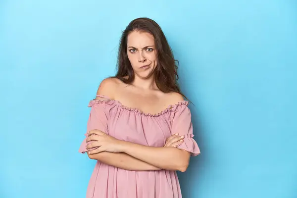 Young Woman Wearing Pink Dress Blue Studio Backdrop Frowning Face — Stock Photo, Image