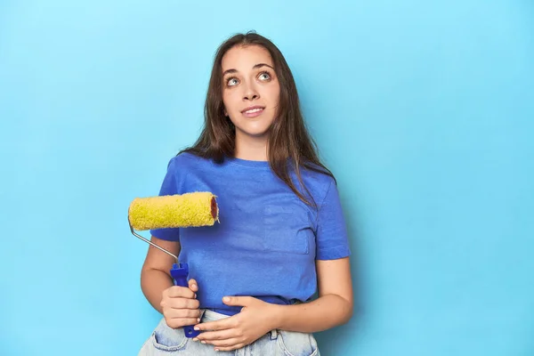 Jonge Vrouw Met Gele Verfrol Een Blauwe Achtergrond Dromen Van — Stockfoto