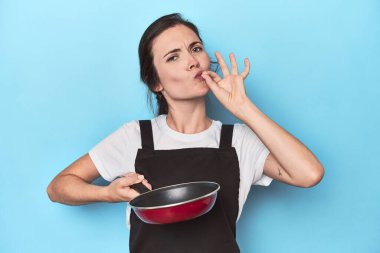 Kendine güveni olan genç bir aşçı, maviye karşı neşeli bir tutum.