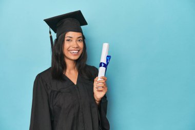 Mavi stüdyoda diploma ve şapkayla Filipinli mezuniyeti kutluyoruz.