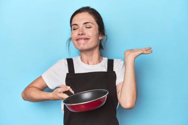 Kendine güveni olan genç bir aşçı, maviye karşı neşeli bir tutum.