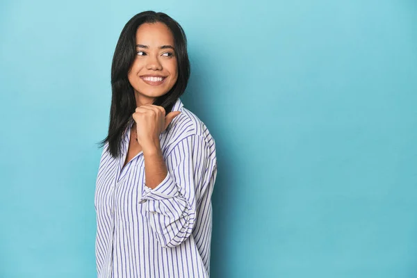 Filipina Young Woman Blue Studio Points Thumb Finger Away Laughing — Stock Photo, Image