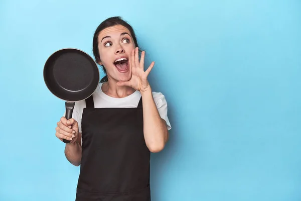 Woman Apron Pan Blue Background Shouting Holding Palm Opened Mouth — Stock Photo, Image