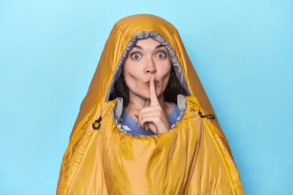 穿着蓝色背景睡袋的女人保守秘密或要求安静 — 图库照片
