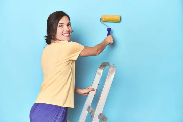 Merdivenden Mavi Bir Duvar Boyayan Kadın — Stok fotoğraf