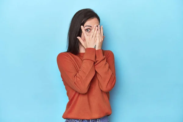 Jonge Blanke Vrouw Blauwe Achtergrond Knipperen Door Vingers Bang Nerveus — Stockfoto
