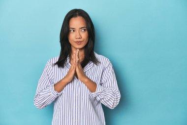 Mavi stüdyodaki Filipinli genç kadın bir plan yapıyor..