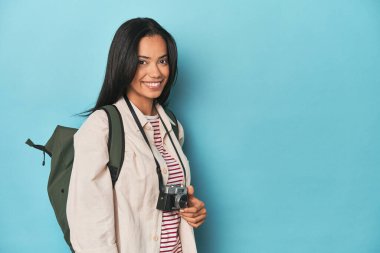 Genç Filipinli, mavi bir stüdyoda kamera ile anları yakalıyor.