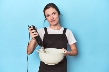 Karıştırıcılı genç şef maviden bir vurucu hazırlıyor.