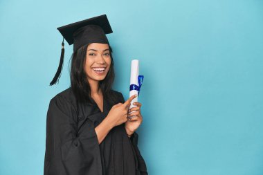 Mavi stüdyoda diploma ve şapkayla Filipinli mezuniyeti kutluyoruz.