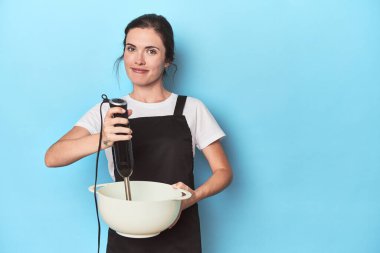 Karıştırıcılı genç şef maviden bir vurucu hazırlıyor.