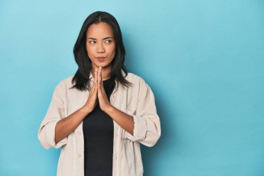 Mavi stüdyodaki Filipinli genç kadın bir plan yapıyor..