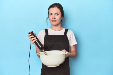 Karıştırıcılı genç şef maviden bir vurucu hazırlıyor.