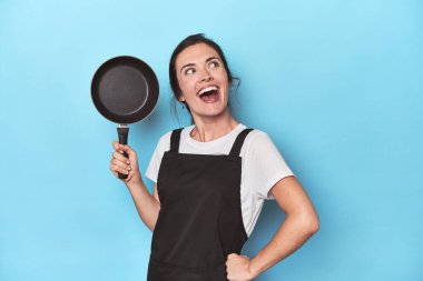 Kendine güveni olan genç bir aşçı, maviye karşı neşeli bir tutum.