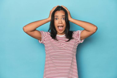 Mavi stüdyodaki Filipinli genç kadın çığlık atıyor, çok heyecanlı, tutkulu, bir şeyden memnun..