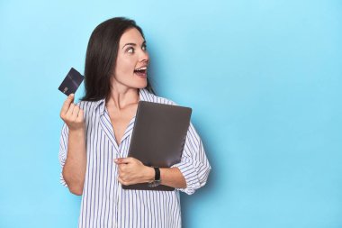 Dizüstü bilgisayarı ve mavi kartı olan bir profesyonel.