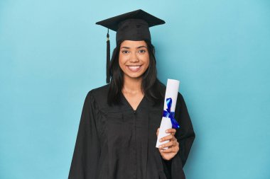 Mavi stüdyoda diploma ve şapkayla Filipinli mezuniyeti kutluyoruz.
