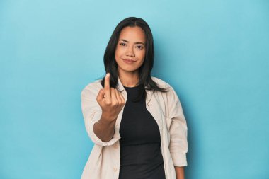 Mavi stüdyodaki Filipinli genç kadın sanki seni davet ediyormuş gibi seni işaret ediyor..