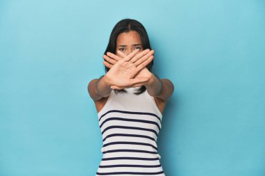 Mavi stüdyodaki Filipinli genç kadın inkar jesti yapıyor.