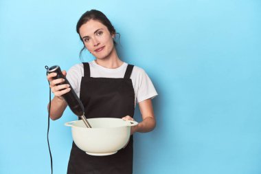 Karıştırıcılı genç şef maviden bir vurucu hazırlıyor.