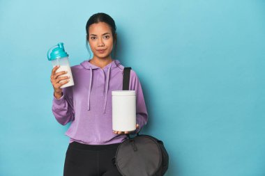 Mavi stüdyoda protein içeceği ve tozuyla Filipinli sporcu