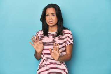 Mavi stüdyodaki Filipinli genç kadın tiksinti gösteren birini reddediyor..