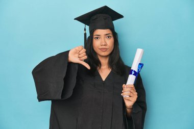 Mavi stüdyodaki diplomasıyla Filipinli mezunu. Sevimsiz bir hareket sergiliyor. Anlaşmazlık konsepti.