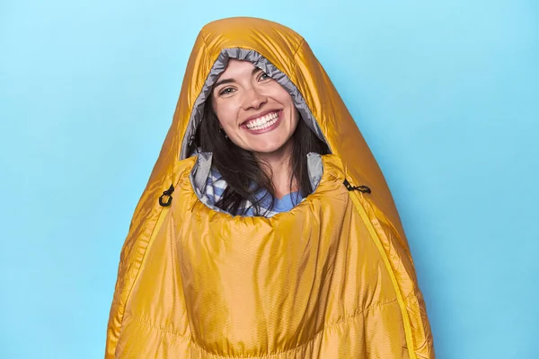 青い背景の寝袋で幸せで 笑顔で陽気な女性 — ストック写真