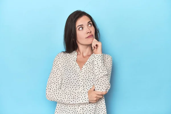 Young Caucasian Woman Blue Backdrop Thinking Looking Being Reflective Contemplating — Stock Photo, Image