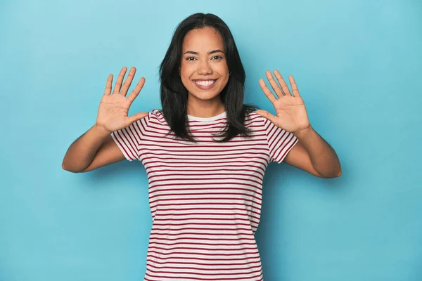 Филиппинка Молодая Женщина Голубой Студии Показывает Номер Десять Руками — стоковое фото