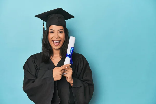Filipina Graduate Diploma Blue Studio Smiling Pointing Aside Showing Something — Stock Photo, Image
