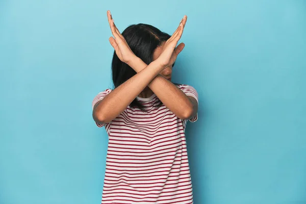 年轻的菲律宾女子在蓝色工作室保持双臂交叉 否认的概念 — 图库照片