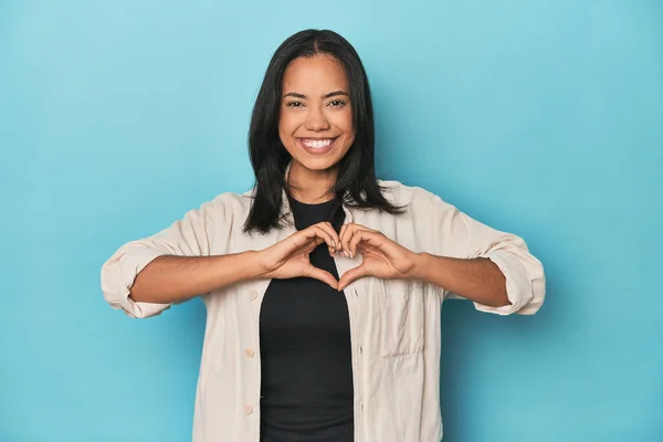 Filipina Joven Estudio Azul Sonriendo Mostrando Una Forma Corazón Con —  Fotos de Stock