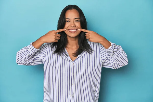 Filipina Joven Estudio Azul Sonríe Señalando Con Los Dedos Boca —  Fotos de Stock