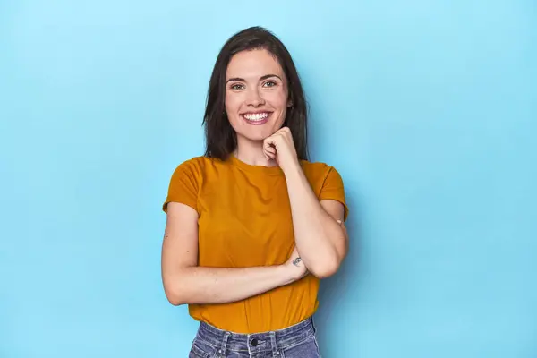 Young Caucasian Woman Blue Backdrop Smiling Happy Confident Touching Chin — Stock Photo, Image