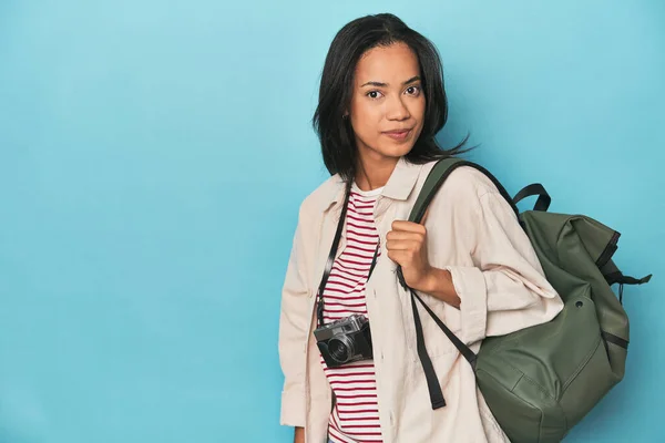 Filipina Aparatem Fotograficznym Plecakiem Podróżnym Niebieskim Tle Studio — Zdjęcie stockowe