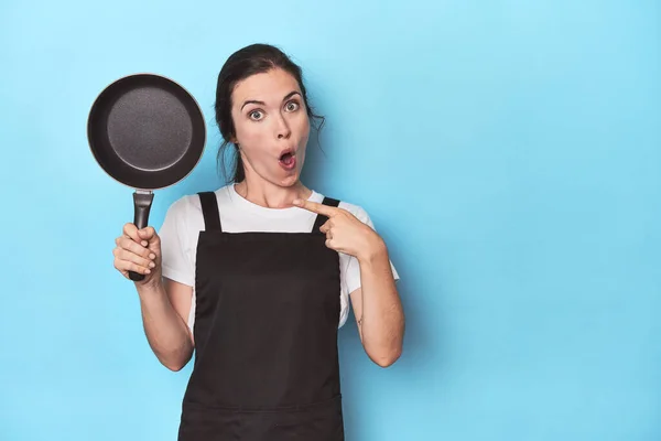 Woman Apron Pan Blue Background Pointing Side — Stock Photo, Image