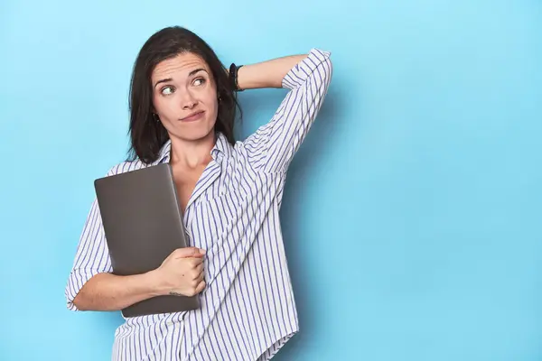 Young Businesswoman Holding Laptop Blue Touching Back Head Thinking Making — Stock Photo, Image