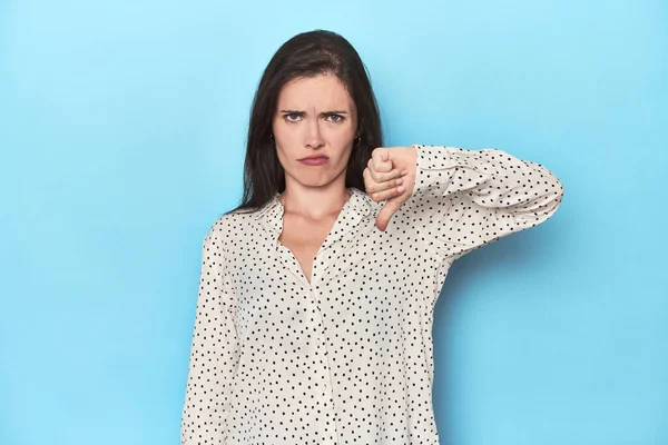 Young Caucasian Woman Blue Backdrop Showing Thumb Disappointment Concept — Stock Photo, Image